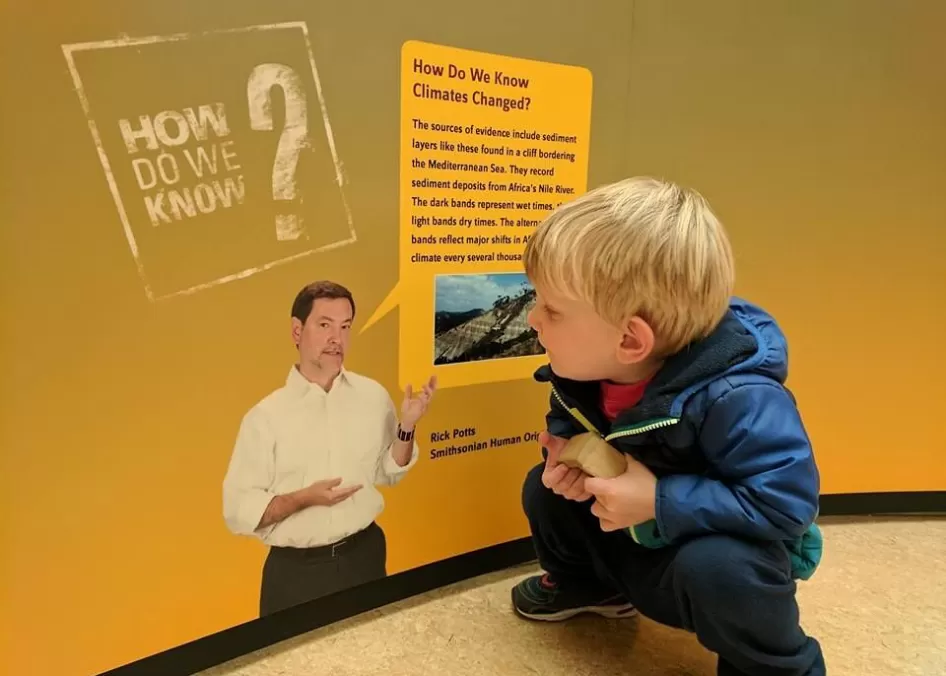 小孩看气候信息在旅游人类起源exhbit汤普金斯县公共图书馆在伊萨卡岛,纽约